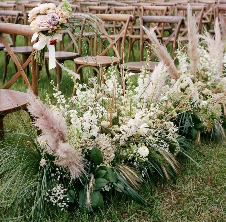 Hansell and Matt's florals lining the aisle at their Alabama wedding