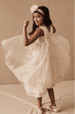 flower girl wearing a pink dress with a butterfly on the back