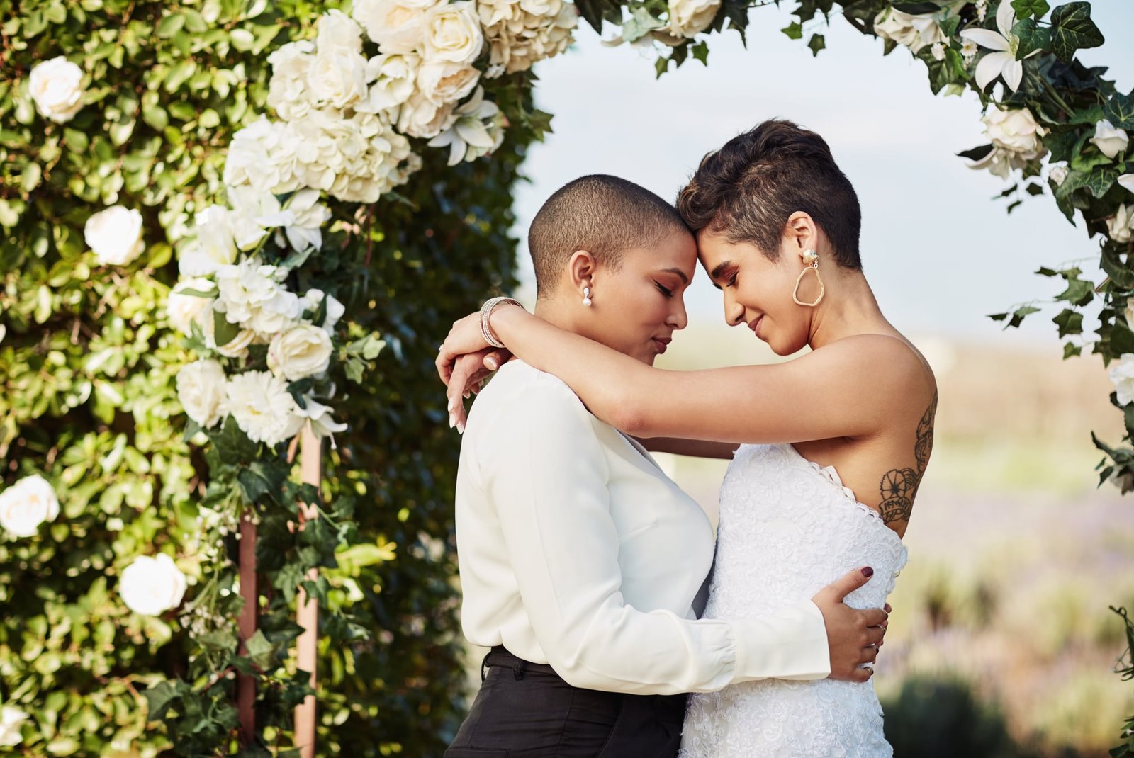 Cropped shot of an affectionate young lesbian couple sharing an intimate moment with their arms around each other on their wedding day